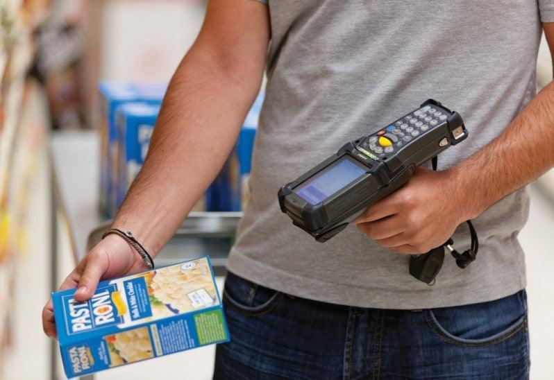 Funcionário usando coletor de dados para inventário em supermercado, tecnologia de automação comercial