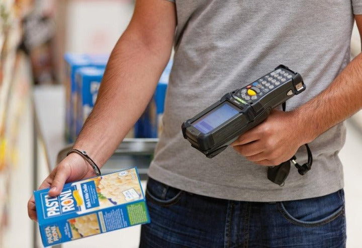 Funcionário usando coletor de dados para inventário em supermercado, tecnologia de automação comercial